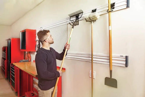 Man organizing tools with VersaTrack Garage Storage Rail With Twenty Piece Mounting Accessories For Drywall Studs And Masonry Pegboard