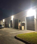 Go-To 120W LED Wall Pack Light With Dusk To Dawn Photocell Glass Lens installed on warehouse exterior for security lighting