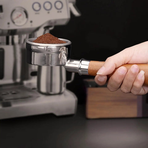 Kick Up Your Morning Vibes With This Rock Solid 58mm Bottomless Portafilter Built For Breville Dual Boiler Espresso Makers Dope Pulls And Creamy Shots Daily. Hand holding 58mm portafilter filled with ground coffee.