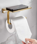 Solid Brass Toilet Paper Holder With Gold Finish, Hotel Style Tissue Roll Holder Plus Built In Cell Phone Shelf, Rust Resistant Chrome Finish, Pro Grade Heavy Duty Bathroom Organizer For Rolls Up To 5.31 Inches on a marble wall