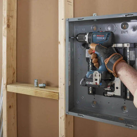 Rock Solid 1/2 Inch Hammer Drill Driver Kit Brushless Motor 565 In-Lbs Torque Core18V Battery in action on electrical panel.