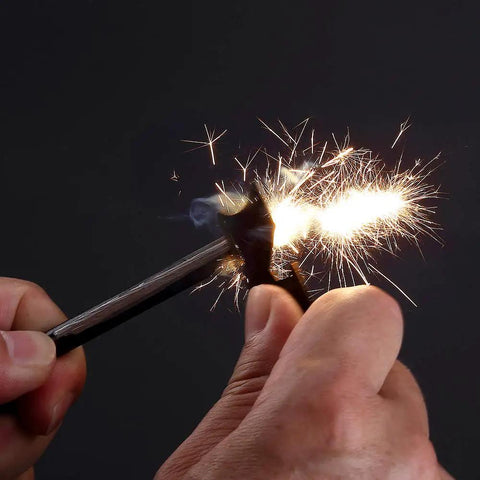 Close-up of hands using 2 Pack Compact Fire Starters With Scraper Striker igniting sparks in dark background.