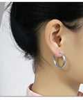Profile of person wearing 20mm silver hoop earrings, showing comfortable fit and minimalist design.