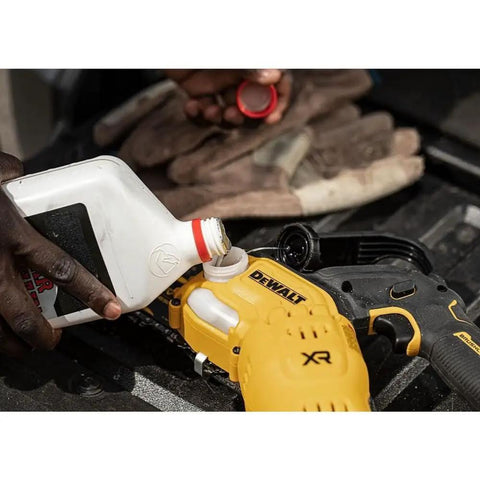 Person refilling oil in yellow Cordless Pruning Chainsaw 20V 8 Inch for quick yard trims, DCCS623B Model