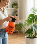 Woman using 0.53 Gallon Handheld Pump Sprayer With Adjustable Copper Nozzle For Plants And Lawn Care on indoor plant.