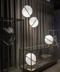 Three Acrylic Globe Pendant Lights With Irregular Hanging Design For Dining Room And Living Room Adjustable Cable 110 To 140 Volt UL Certified Includes Gold Ceiling Mount And Hardware For A Sleek Modern Vibe elegantly displayed in a room setting.