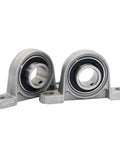 Super Heavy Duty Pillow Block Bearings 4 Pack Universal Mounted Units For Machines And Engines Easy Insert Smooth Runs Top Shelf Steel Built Tough No Slack During Fast Operation Big Savings On Pro Gear For Your Shop Jobs Ready To Ship Fast Delivery. Two steel pillow block bearings on white background