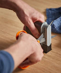 "Clip Sharp Scissors Sharpener For All Scissors, Quick No Fuss Sharpening, Extends Shears Life in action on a wooden table."
