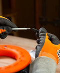Klein Tools 56025 non-conductive fish tape repair kit held by gloved hands; white plastic rod, orange coil nearby.