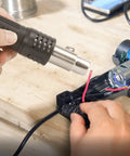 Hot Air Rework Station For Electronics Repair With Digital Display Heat Gun, Three Temperature Presets, tool in use on PCB