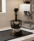 Solid Game Changer Espresso Pin Distributor And Coffee Clump Breaker Tool For Portafilter on countertop, 58 mm, black aluminum.