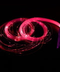 Lit Fiber Optic Space Dancing Light Whip with Rechargeable LED glowing in red, showing fiber optic strands, ideal for EDM parties.