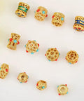 Grab These Dope Hollow Transfer Beads For Your Next DIY Jewelry Build And Stack Up Some Fire Sand Gold Spacer Charms Featuring A Sleek Baking Lacquer Coating Perfect For Chilling With Bracelets Necklaces Earrings And Custom Keychain Projects - assorted gold beads with red and turquoise accents