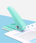Grab And Go Handheld One Quarter Inch Hole Punch For Up To Twenty Sheets, Metal Hole Puncher, green on blue surface with paper