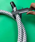 Hand measuring Replacement Steam Hose For Garment Steamer Flexible High Temperature Resistant Tube with caliper on green background