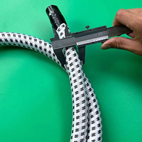 Hand measuring Replacement Steam Hose For Garment Steamer Flexible High Temperature Resistant Tube with caliper on green background