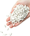 Hand holding Eight Pound Ceramic Tumbling Media Cylinders, Reusable Non Abrasive Pellets 1/5 x 2/5 Inch For Lapidary Tumblers And Stone Polishers