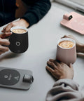 Level Up Your Morning Vibe This Smart Mug Warmer Game Changer Keeps Your Daily Brew Piping Hot With Precision Temp Control 15 Oz Ceramic Mugs Lids And Spoons Simple Cord Setup, showcasing black and pink ceramic mugs with a grey warming base.