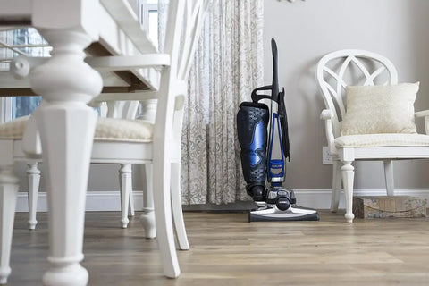 Standing vacuum cleaner near dining table with chairs, showcasing Micron Magic HEPA Vacuum Filter Bags 6 Pack For G4 G5 Sentria Avalir G Series