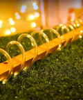 33ft Solar Rope Lights With 100 LEDs, 8 Modes, IP65 Waterproof Tube Lights glowing warmly on outdoor grass surface