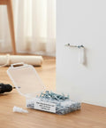 Open box of 100 Pack M10 Nylon Drywall Anchors with screws next to a mounted anchor on white wall