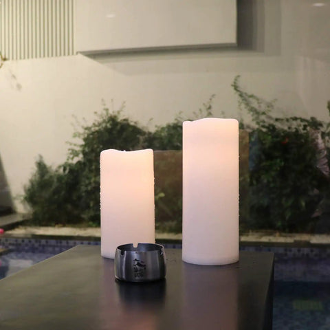Outdoor view of waterproof flameless LED pillar candles with remote and timer, 4 inch diameter, pack of 2, weatherproof.