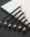 10 Pack Black And Gold Knurled 5 Inch 128mm Hole Center Cabinet Handles for Kitchen Cabinets and Drawer Pulls displayed on black surface