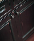 Straight Up Vintage Vibes With These Killer Weathered Nickel Cabinet Knobs with recessed concentric rings on dark cabinet.