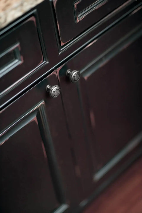 Straight Up Vintage Vibes With These Killer Weathered Nickel Cabinet Knobs with recessed concentric rings on dark cabinet.