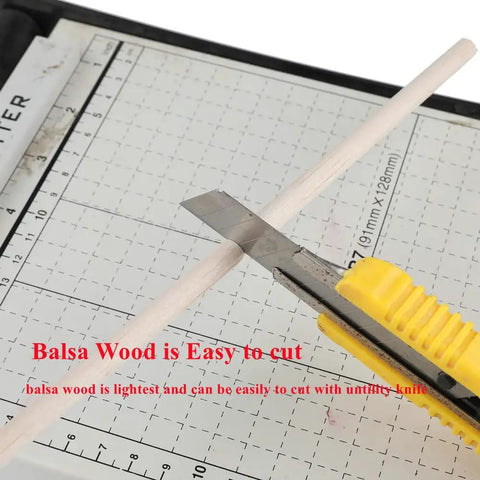 Cutting Top Shelf Unfinished Balsa Wood Dowels 12 Pack with a utility knife on a grid cutting mat.