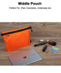 Middle pouch of the Three Pack Travel Toiletry Bags for Men Carry-On Organizer Pouch Set, shown with iPad and cosmetics, in orange.