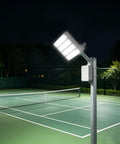 Stadium Flood Light 200W IP67 Water-Resistant 180° Adjustable Bracket on a pole illuminating a tennis court at night.