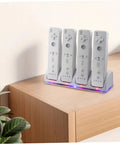 4 In 1 Battery Charging Station for Game Controllers on tabletop, charging four gaming remotes with LED indicators, USB cable visible