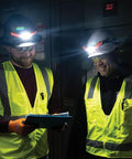 Two workers wearing safety helmets with Rechargeable LED Wide Beam Headlamp With Hard Hat Mounts For Work, 770 Lumens in dimly lit space.