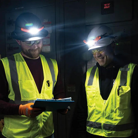 Two workers wearing safety helmets with Rechargeable LED Wide Beam Headlamp With Hard Hat Mounts For Work, 770 Lumens in dimly lit space.