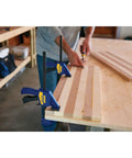 Two Six Inch Mini Bar Clamps securing wood pieces on a workbench, demonstrating quick release trigger for woodworking projects.