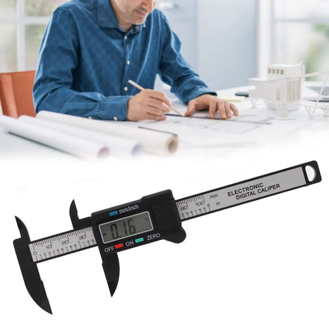 YUEHISY Digital Caliper Mini LED 0 100mm Plastic Lightweight Portable measuring item on paper, showing 0.16 mm reading.