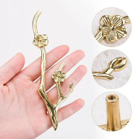 Slick Twig Drawer Pulls In Polished Brass Plum Blossom Branch Handle, shown in hand, highlighting flower detail and installation.