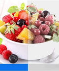 Bowl of mixed fruit salad with strawberries, raspberries, and mint leaves, vibrant colors, healthy snack option.