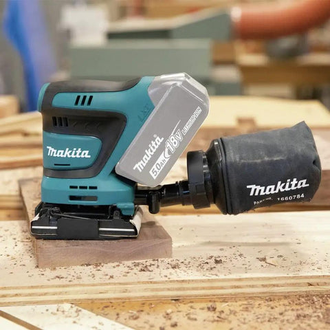 18V Cordless 1/4 Sheet Finishing Sander With Two Speed Control 11K And 14K OPM Uses Four And A Half Inch By Four Inch Abrasive Paper Large Clamping Lever Tool Only on a wooden plank
