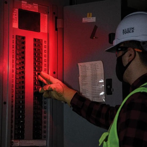 Person using Rechargeable Two Color LED Headlamp with Durable Fabric Strap in red mode, examining electrical panel.