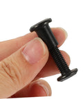 Kickass Black Stainless Steel M6 X25 Chicago Screw held between fingers, perfect for leather crafting and bookbinding needs.