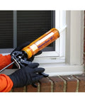 Close-up of Heavy Duty Black Caulk Sealant being applied with a gun at a window joint for weatherizing moving joints.