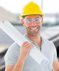 Man wearing yellow hard hat and clear anti-fog safety glasses, holding blueprints, showcasing 12 Pack Clear Anti Fog Safety Glasses With Wraparound Lenses.