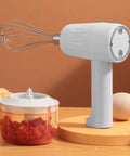 Cordless Electric Hand Mixer With Stainless Steel Beaters on wooden table, featuring a chopping bowl with vegetables.