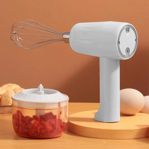Cordless Electric Hand Mixer With Stainless Steel Beaters on wooden table, featuring a chopping bowl with vegetables.