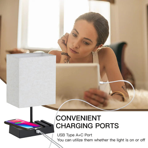 Two Pack Bedside Lamps With Wireless Charging, USB A And USB C Ports, And AC Outlet next to woman using tablet
