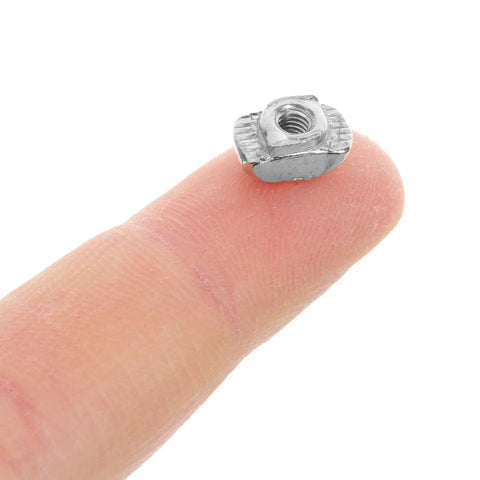 Kick Your 3d Printer Game Up With 40 Piece M3 T Slot Nuts Made From Tough Carbon Steel on a finger for scale.