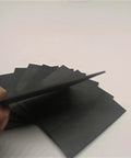 Person holding High Temperature Graphite Plate For Pyrolysis Block Anode Anti Corrosion Heat Sink 100x50x2mm 5 Pieces set