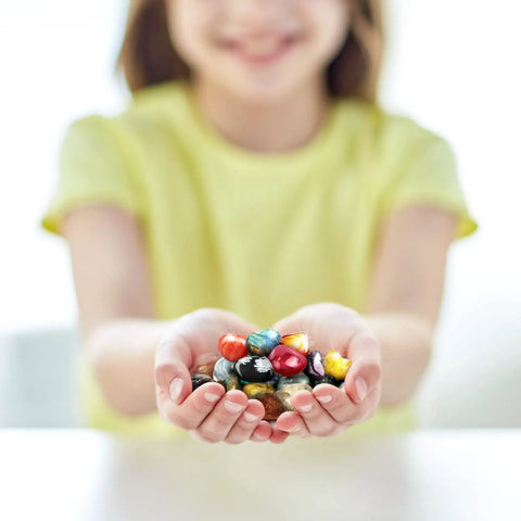 Child holding 25-piece rock and mineral kit with real rocks, gemstones, and crystals for geology learning